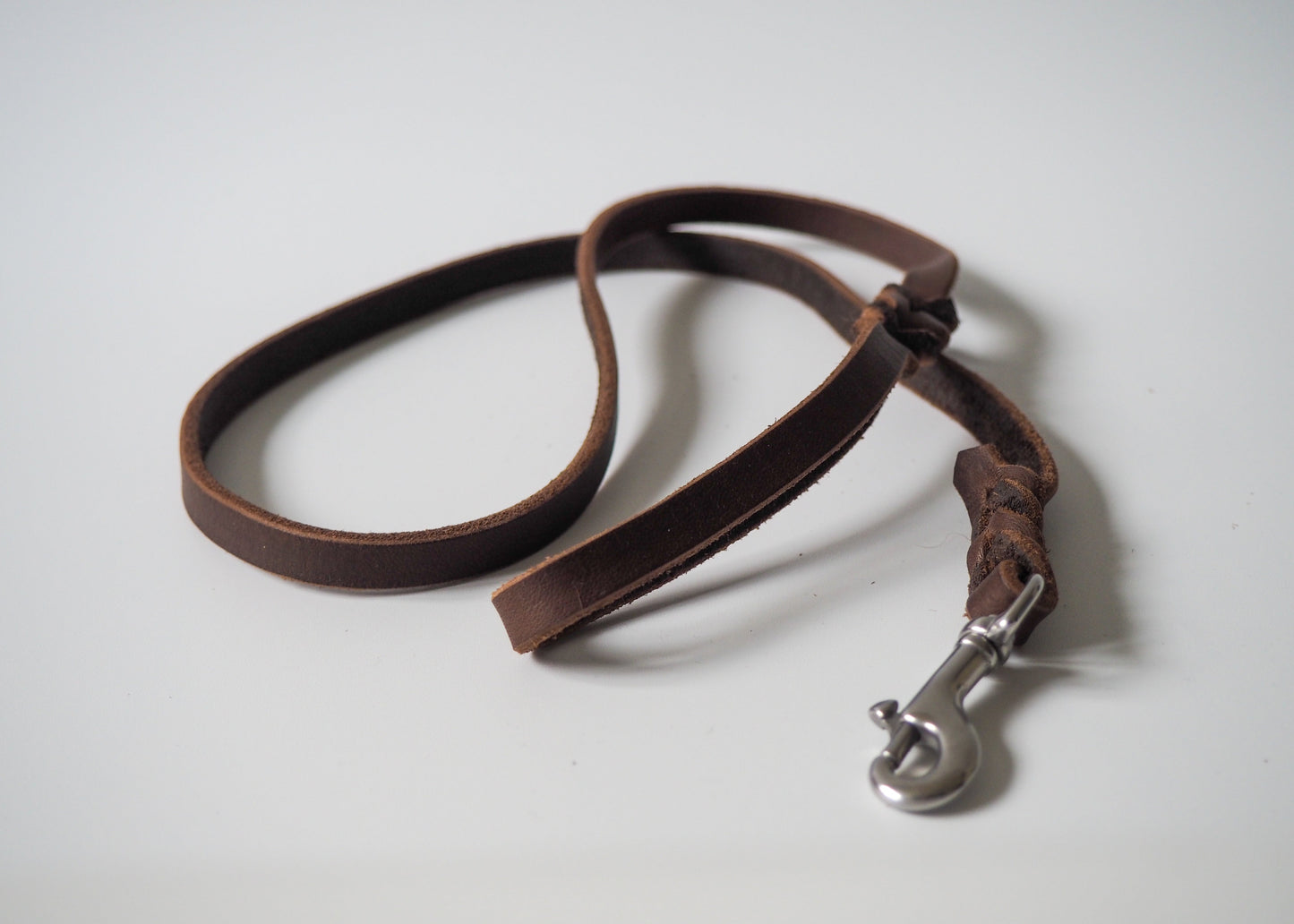 Geflochtene Führleine aus einfarbigem Leder mit Handschlaufe auf weißem Hintergrund – robust, stilvoll und handgefertigt für Hunde aller Rassen