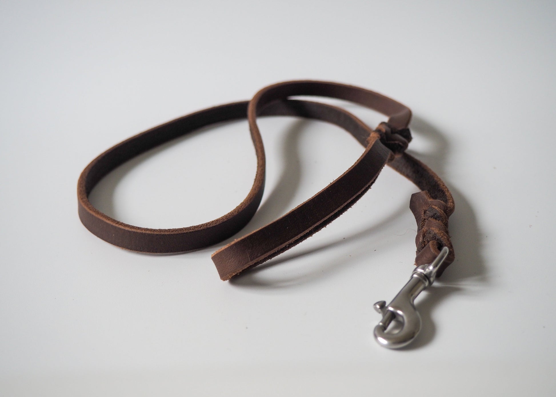 Geflochtene Führleine aus einfarbigem Leder mit Handschlaufe auf weißem Hintergrund – robust, stilvoll und handgefertigt für Hunde aller Rassen