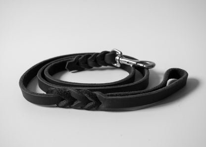 Geflochtene Führleine aus einfarbigem Leder mit Handschlaufe auf weißem Hintergrund – robust, stilvoll und handgefertigt für Hunde aller Rassen